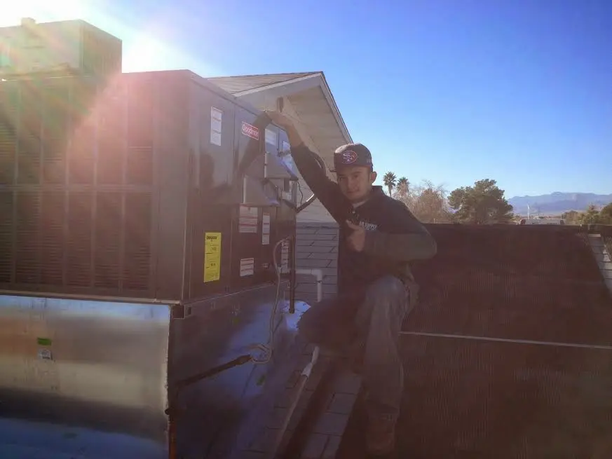 HVAC technician performing Boiler Repair on a rooftop unit in Jefferson